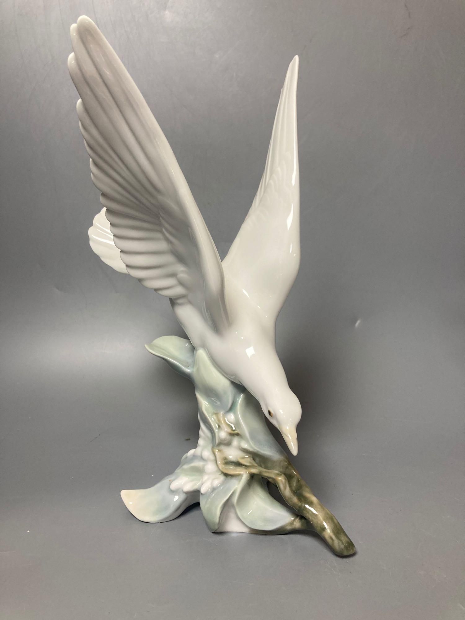 A Lladro figure of a geisha, 30cm high and another of a seagull, 29cm high and a Nao figure of a baby, length 21cm